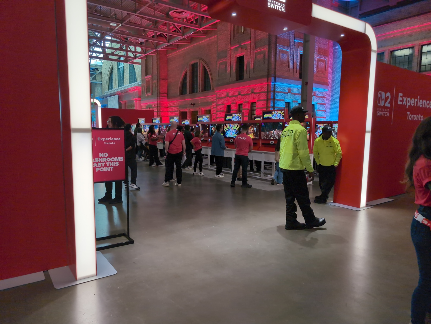 Photo of the Donkey Kong Bananza exhibition area from behind the gate to the free‐play area. A sign at the gate reads “NO WASHROOMS PAST THIS POINT”.