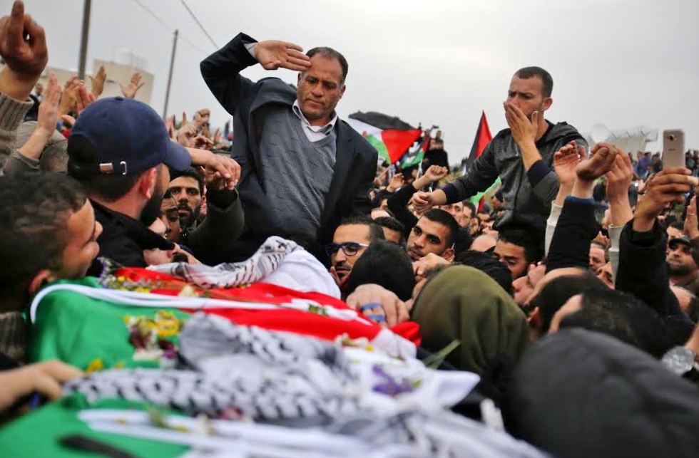 Basil's father salutes his son's body during the funeral.