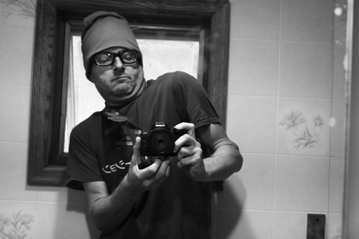 Photo of a man twisting his body to hold a camera