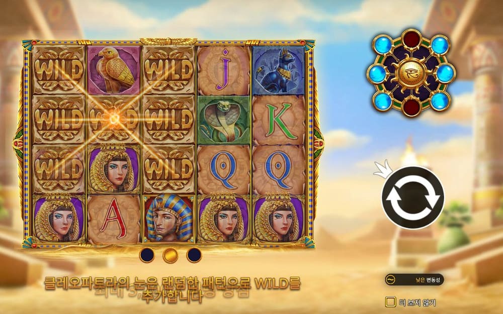 아이 오브 클레오파트라 사암 격자에 여러 WILD 타일, 클레오파트라 초상과 A·Q·J 글자가 보이고 오른쪽에는 보석 원판이 있습니다