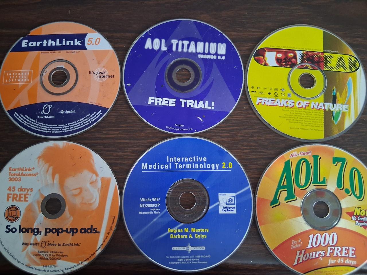Five AOL and EarthLink internet free trial CDs found at the side of the road, as well as "Interactive Medical Terminology 2.0". The discs are dated 1996-2003